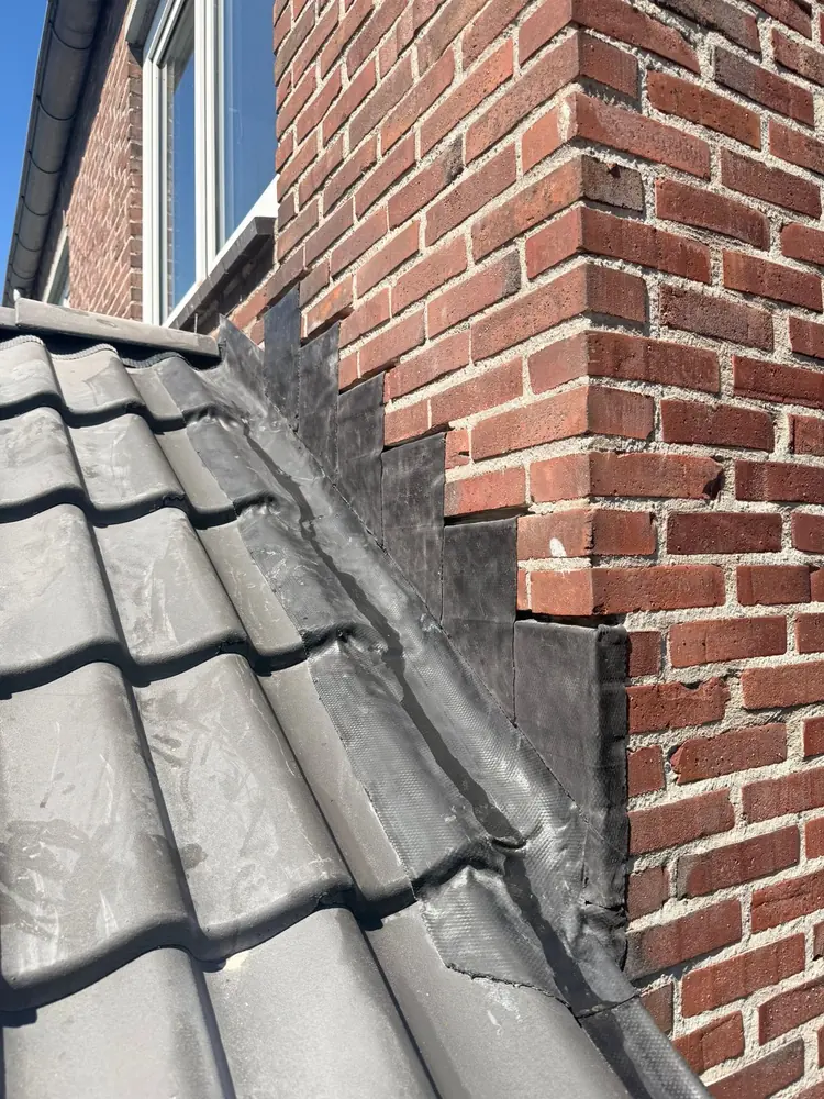 Loodindekking tegen de gevel in Brunssum, uitgevoerd door Adams Daktechniek